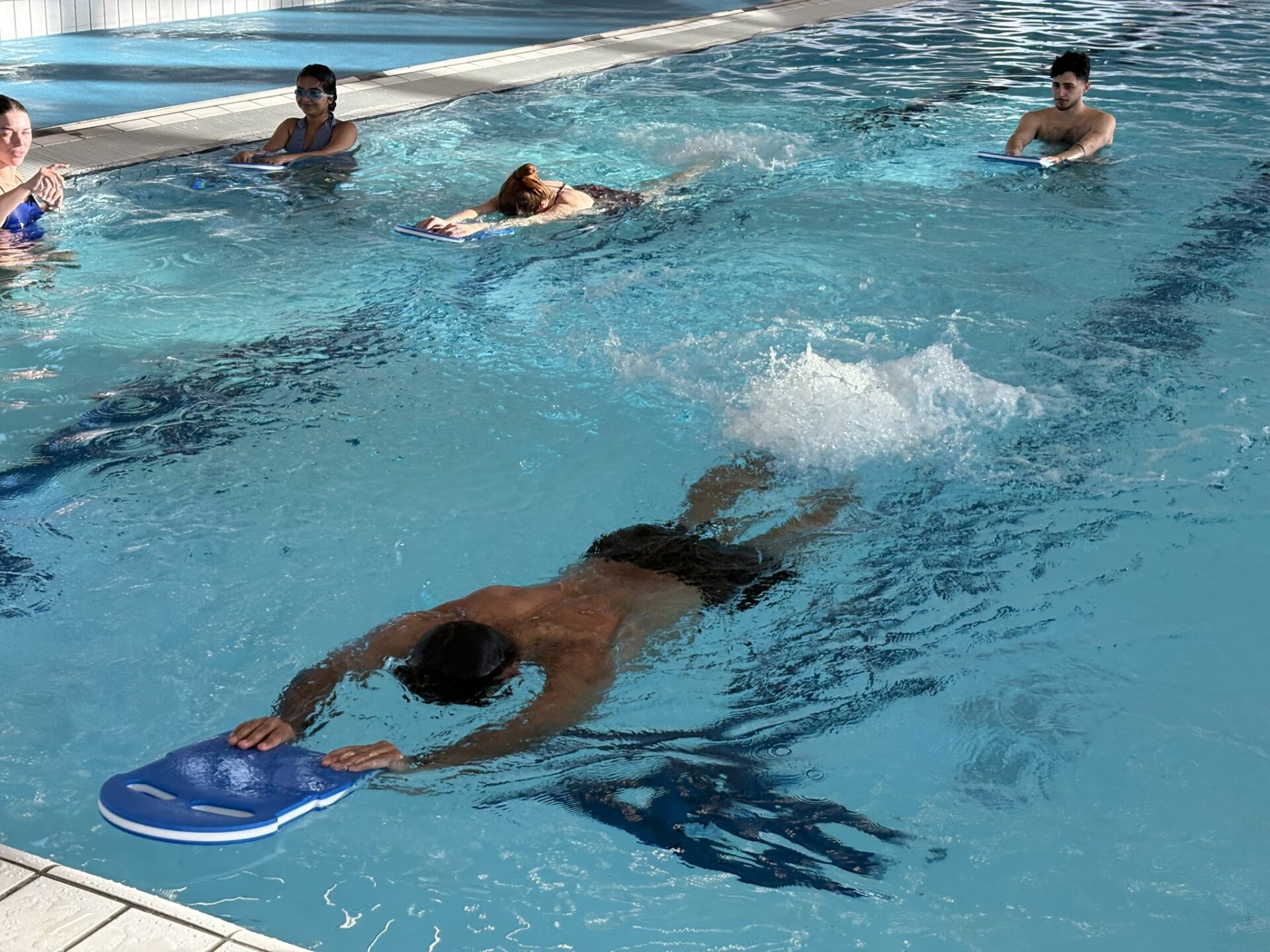 Adult practising first flutter kicks during beginner swimming lesson
