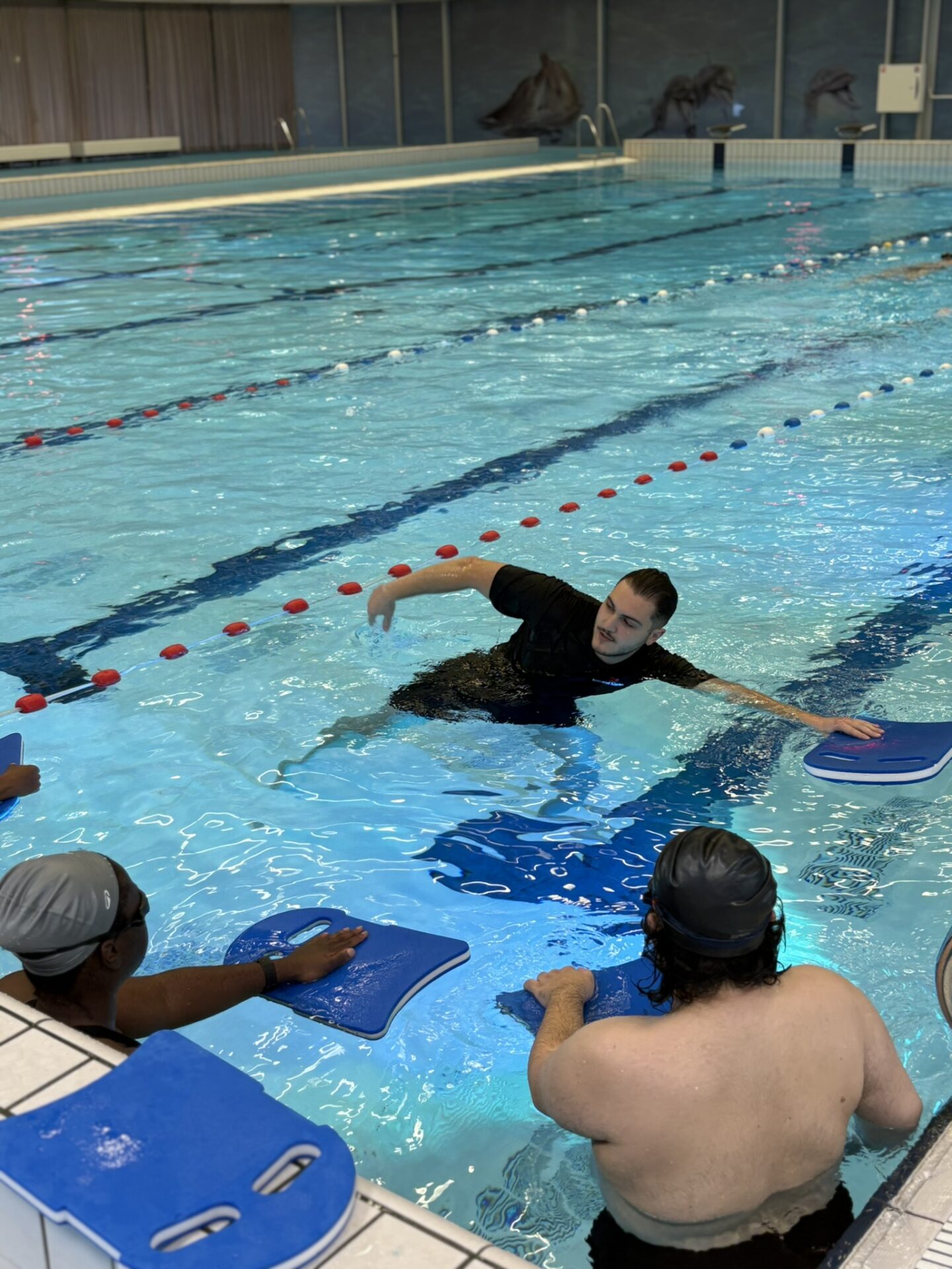 Adult learning first freestyle strokes in beginner swimming lesson